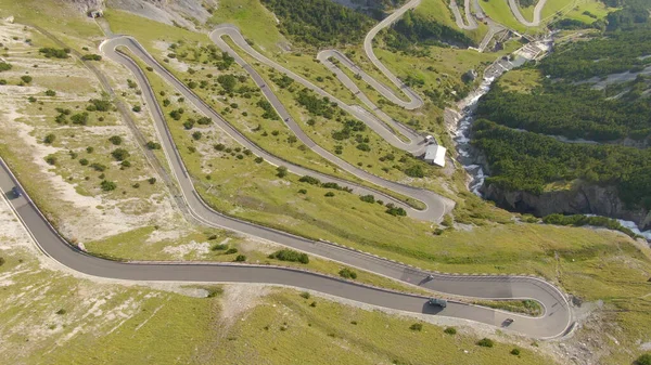 DRONE: Volando por encima de un coche y una motocicleta que conduce por carreteras con curvas en Italia . — Foto de Stock