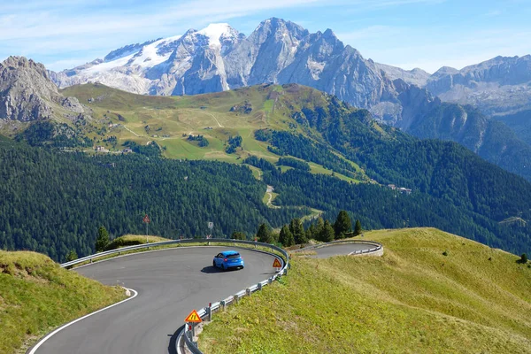 DRONE: Blue rally car drives towards a sharp turn in beautiful sunny Dolomites. — Stock Photo, Image