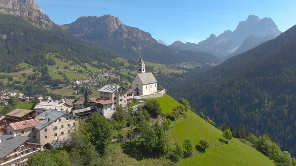 DRONE: Létání nad kostelem a malým hřbitovem na vrcholu kopce v Dolomitech. — Stock fotografie