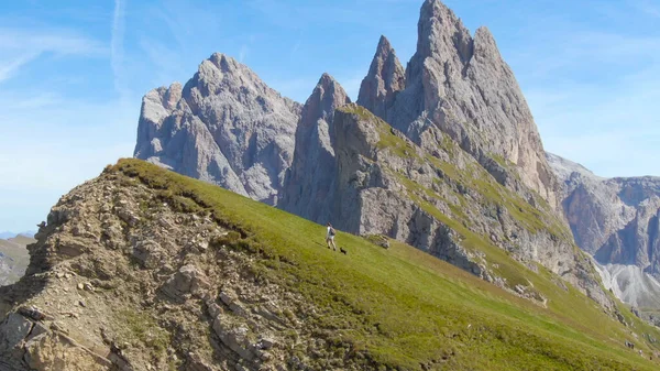 DRONE: Young girl taking her dog for a walk in the stunning Italian mountains. — Photo