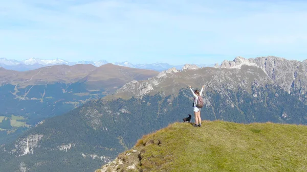 AERIAL: fiatal nő túrázás a Dolomitok ünnepli eléri a csúcsra. — Stock Fotó