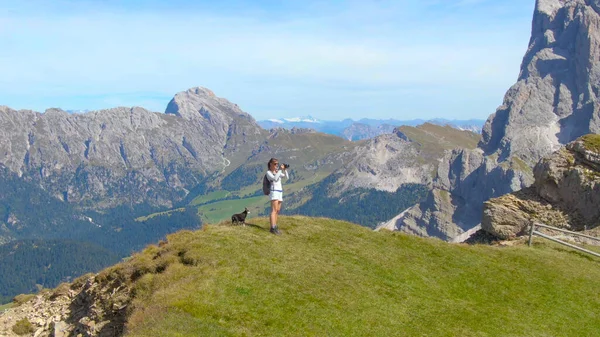 Női turista megáll a hegytetőn, hogy lefotózza a tájat — Stock Fotó