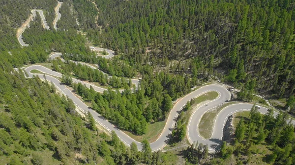DRONE: Coches y motocicletas conducen a lo largo de las horquillas serpenteando a través del bosque . — Foto de Stock