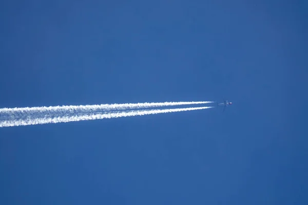 VERTICAL BOTTOM UP: Airplane flies across the sky, leaving a long white trail. — Foto Stock