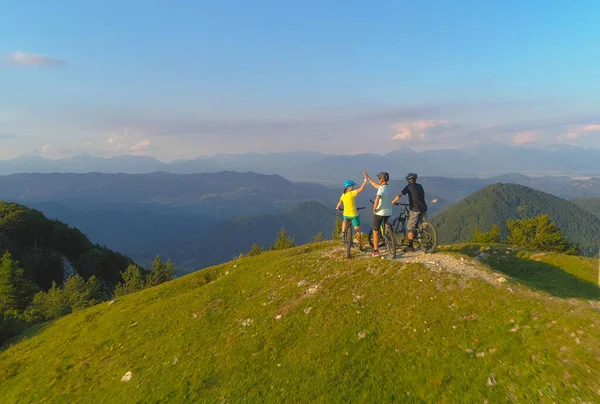 DRONE: baráti társaság pacsizás után sikeres biciklizés a zöld hegyekben — Stock Fotó