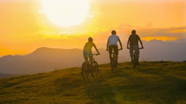 SUN FLARE Young cross country cyclists enjoying a relaxing ride on sunny evening