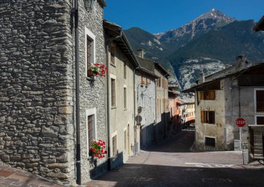 The breathtaking Alps tower above the quiet sunlit medieval town in France.
