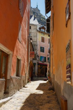 Summer sunshine illuminates the colorful streets of a medieval town in France.