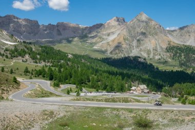 AERIAL: Flying above the empty switchback road running past a roadside hotel.