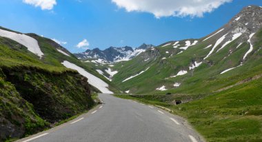 Travelers in black car drive along the scenic road running through the valley.