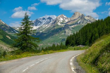 Scenic mountain road turns into the forest in the picturesque French Alps.