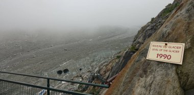 CLOSE UP: Old bilingual sign signalling where the level of a glacier was in 1990
