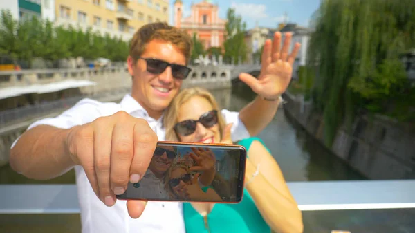 CLOSE UP: Happy tourist couple filming a vlog from picturesque sunny Ljubljana — Foto de Stock