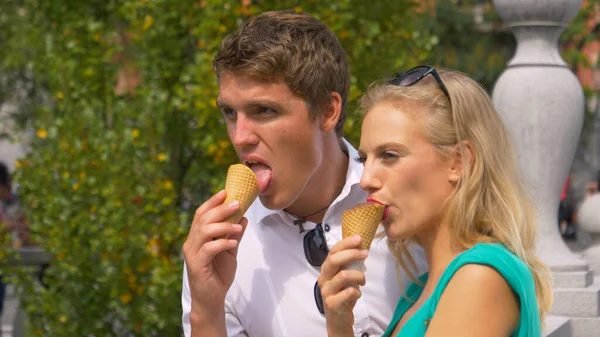 Sluiten omhoog: Gelukkig man kussen en zijn vriendin eten smakelijke gelato in Ljubljana. — Stockfoto