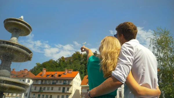 CLOSE UP: Blonde girl points to castle before walking towards it with boyfriend. — Foto de Stock