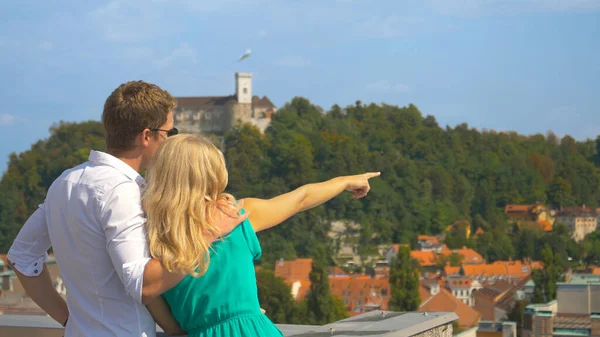CLOSE UP: Young woman observing the scenic town with boyfriend from a rooftop. — Foto de Stock