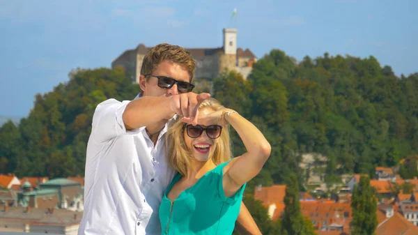 CLOSE UP: Smiling couple observes the scenic cityscape of Ljubljana on sunny day — Stock Photo, Image