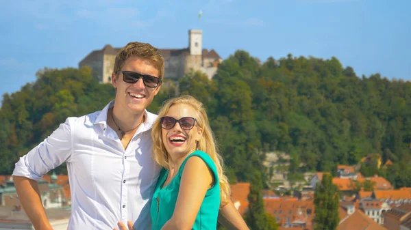 PORTRAIT : Une femme heureuse pose avec son petit ami devant le château de Ljubljana . — Photo