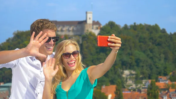 CLOSE UP: Young travelers skyping with friends from rooftop in sunny Ljubljana. — Foto de Stock
