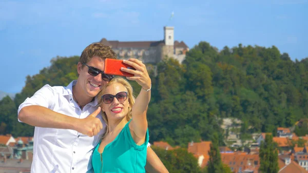 FECHAR UP: Homem sorridente dá os polegares para cima ao tomar selfies com a namorada. — Fotografia de Stock
