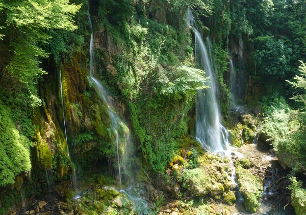 CLOSE UP: Маленькі водоспади обриваються вниз по скелі і на моховинні скелі . — стокове фото