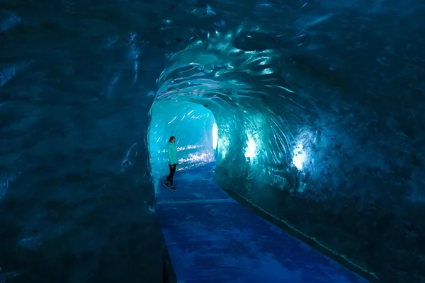 Kvinnlig resenär vandrar längs en stig som löper genom en hisnande glaciär. — Stockfoto