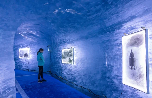 Young woman observes the photos inside of a blue ice cave in the French Alps. — Stok fotoğraf