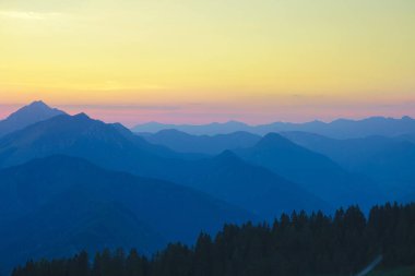 Güneşli bir akşamda Slovenya 'nın altın ışıklı dağlarının üzerinden uçmak.