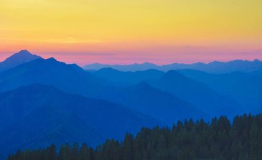 Güneşli bir sabahta Slovenya 'nın altın ışıklı dağlarının üzerinden uçmak.