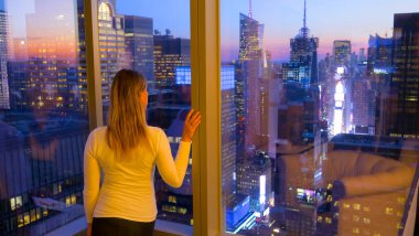 Gün batımında canlı Times Meydanı 'nı izleyen tanınmayan kadın turist..