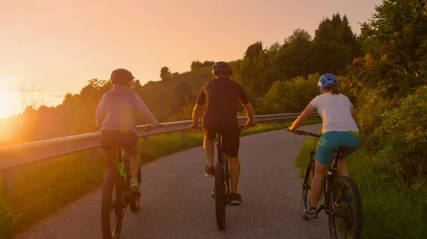 SUN FLARE: Młodzi podróżnicy cieszą się malowniczą wycieczką rowerową w słoneczny poranek. — Zdjęcie stockowe