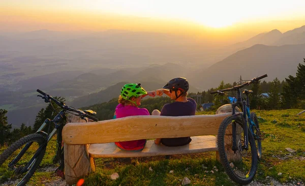 CHIUDI: Giovani motociclisti seduti su una panchina e pugno urto dopo un giro al tramonto. — Foto Stock