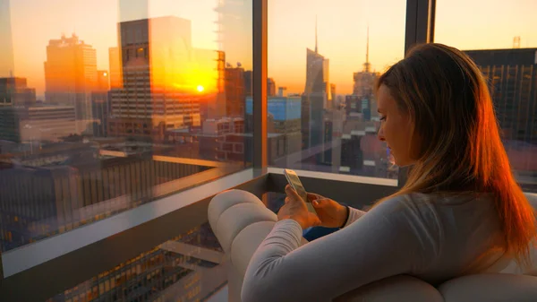 CHIUSURA: Ragazza guarda il suo smartphone dal suo ufficio con vista su Times Square. — Foto Stock