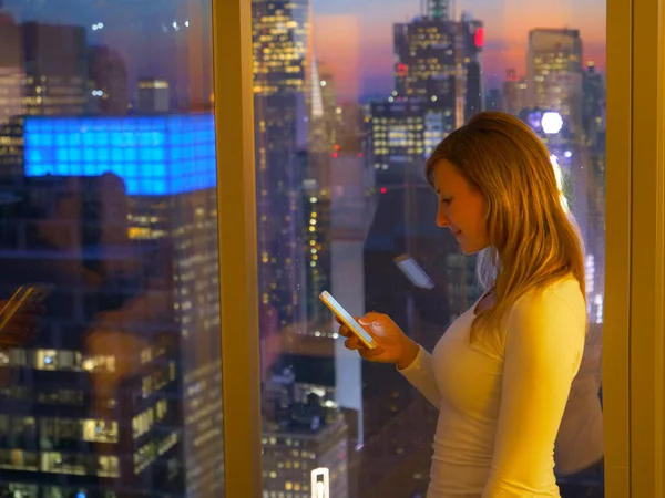 CHIUDI: Le amiche turistiche inviano SMS dalla sua camera sopra Times Square. — Foto Stock