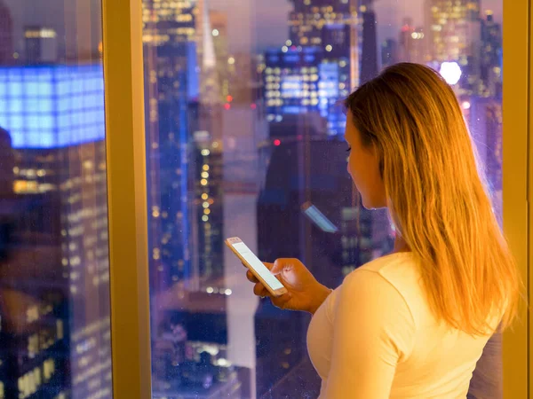 CHIUDI: Ragazza turistica che naviga su internet sul suo telefono mentre si trova nella sua camera d'albergo — Foto Stock