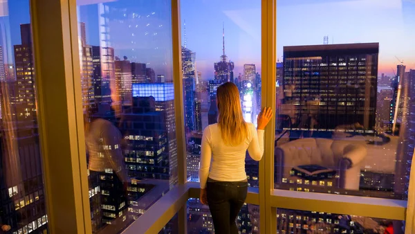 CLOSE : Une jeune femme méconnaissable observe l'horizon nocturne de New York. — Photo