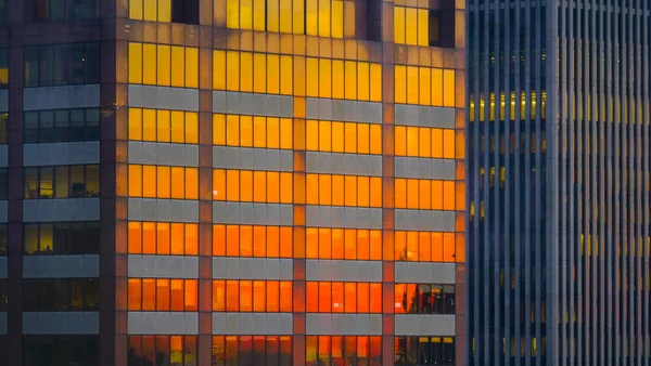 AFSLUITEN: verbrande oranje avondlucht weerkaatst van de ramen van wolkenkrabbers. — Stockfoto