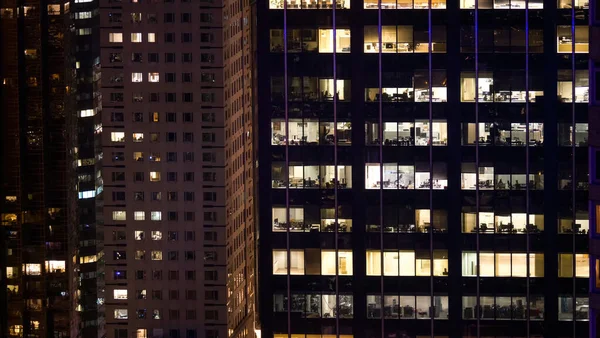 FECHAR UP: Escritórios vazios em arranha-céus corporativos são deixados iluminados durante a noite. — Fotografia de Stock