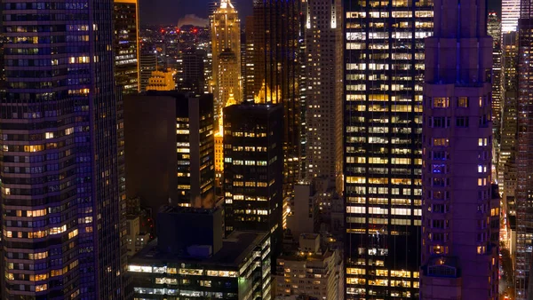 Edificios de oficinas de gran altura se elevan sobre las bulliciosas calles de Nueva York por la noche — Foto de Stock