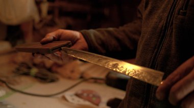 Bladesmith, ahşap kılıfına geleneksel bir bıçak yerleştirir..