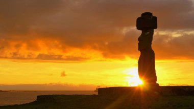 Kara bulutlar kıyıdaki tarihi moai heykelinin üzerinde toplanıyor..