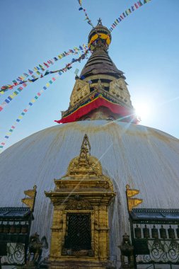 Stupa 'nın tepesinden sarkan bayraklarla dolu iplerin nefes kesici görüntüsü.