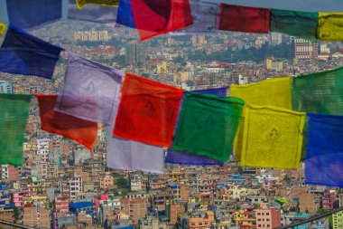 Dalgalanan dua bayraklarının arkasındaki Katmandu şehrinin çarpıcı görüntüsü.