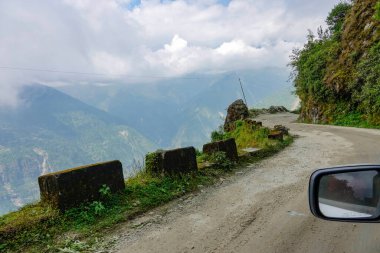 Nepal 'de toprak bir yolda hızla ilerlerken alttaki ormanın korkunç manzarası..