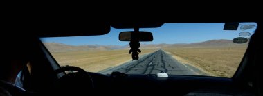 Oyuncak ayı, turistler Tibet 'i keşfederken bir arabanın aynasında asılı duruyor..