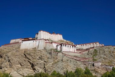 Tibet 'teki devasa kayalık dağın tepesinde büyük bir Budist manastırı bulunuyor.