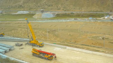 Tibet 'te nehir boyunca devam eden inşaat halindeki bir otoyolun yukarıdan görüntüsü.