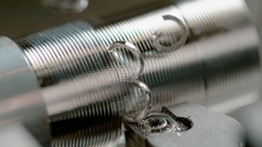 Spiral şekilli çipler alüminyum çubuktan bir cıvataya işleniyor.