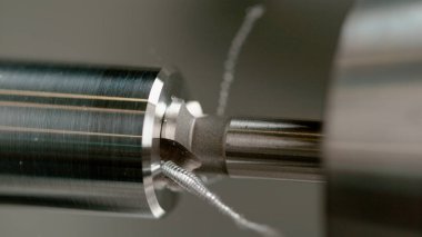 Keskin matkap, parlak alüminyum bir çubuğun ortasında delik açıyor..