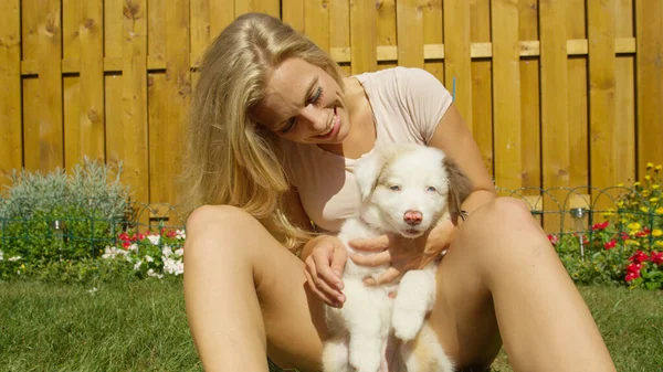 ZAMKNIJ SIĘ: radosna biała dziewczyna uśmiecha się trzymając puszystego białego szczeniaka. — Zdjęcie stockowe